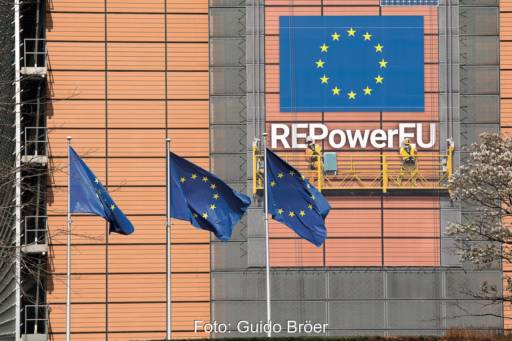 Gebäude der EU-Kommission - rotes Gebäude mit blauen Flaggen davor und blauem Banner.