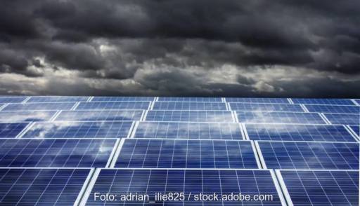 Im Bild dunkle Wolken über eine PV-Anlage als Symbol für die bisher mangelnde Resilienz in der Energiewirtschaft.