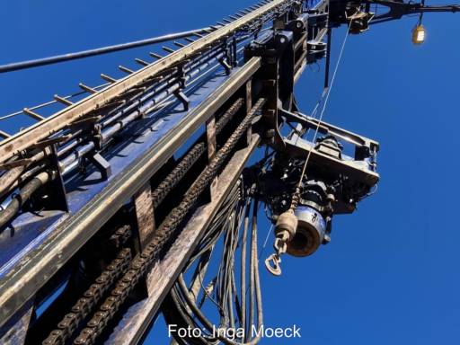 Bohrturm vor blauem Himmel aus Froschperspektive - Bohrgeräte und Fachkräfte gehören zu den kritischen Faktoren für die Geothermie