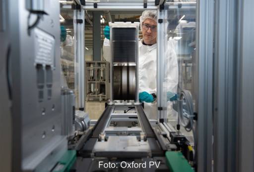 Blick in die Solarzellfertigung mit Mitarbeiter in weißem Laborkittel.