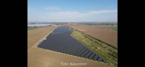 Luftbild eines PV-Großprojektes im Flachland umgeben von brauen Äckern.