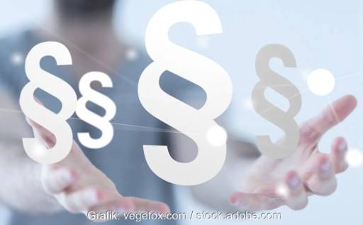 Im Bild zwei Hände mit mehreren Paragrafen als Symbol für das geplante Heizungsgesetz.