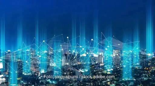 Eine Stadt bei Nacht mit einem Netz aus blau leuchtenden Knotenpunkten - Symbol für Peer to Peer Stromhandel.