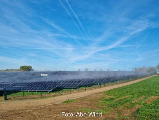 Ein Freiflächen-Solarpark unter blauem Himmel mit Schlierenwolken.