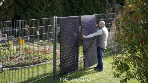 Im Bild ein Mann, der die Zaun-Solaranlage von Greenakku installiert.