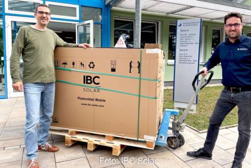 Im Bild zwei Männer mit Ameise und einer Palette mit PV-Modulen für die DGS Solarschule Nürnberg.