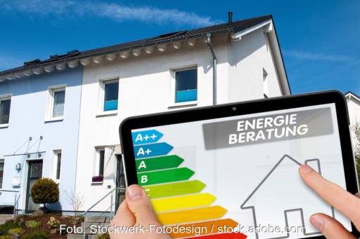Reihenhaus im Hintergrund. Davor die Anzeige einer Gebäudeenergieverbrauchsskala als Symbol für die Energieberatung für Wohngebäude