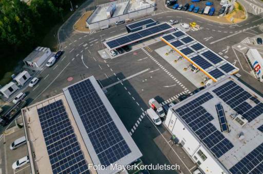 Luftaufnahme von Tankstellen-Gelände mit PV-Modulen auf den Gebäuden.
