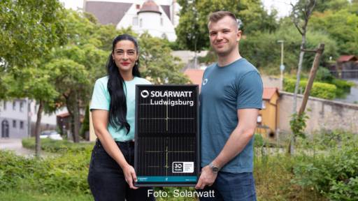 Eine Frau und ein Mann halten ein kleines Solarmodul mit dem Schriftzug Solarwatt Ludwigsburg.